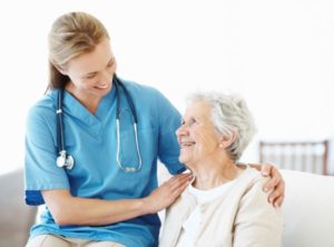 Beautiful doctor and elderly female patient smile at one another - Copyspace